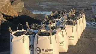 Stor poser med Mekvik logo holder grusmasser